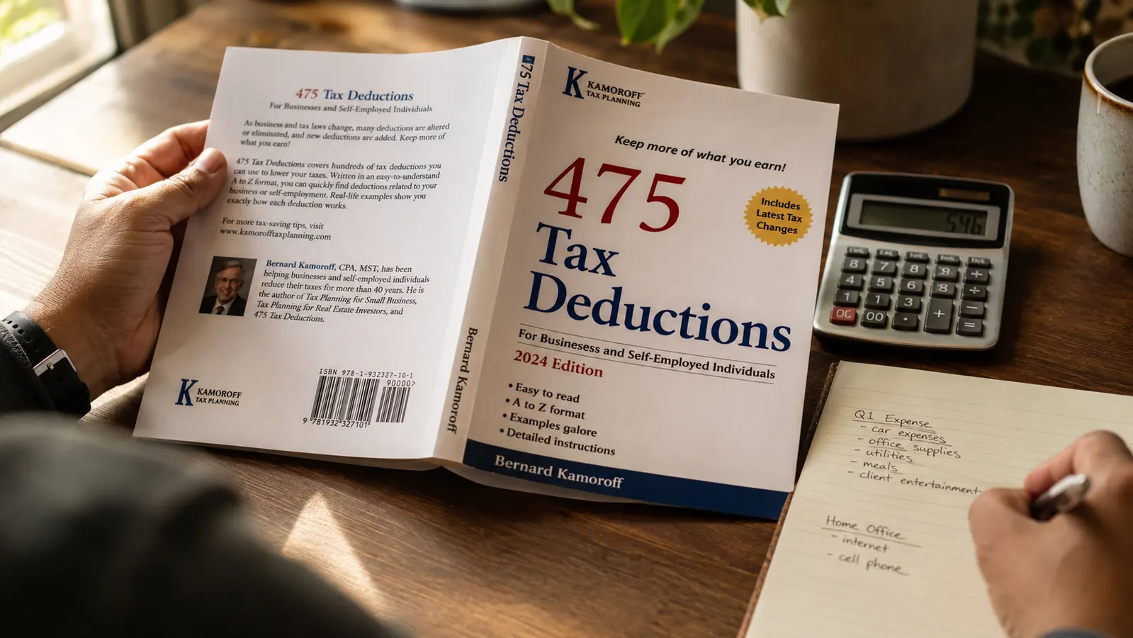 Copy of 475 Tax Deductions for Businesses and Self-Employed Individuals open on a desk next to a calculator and notebook