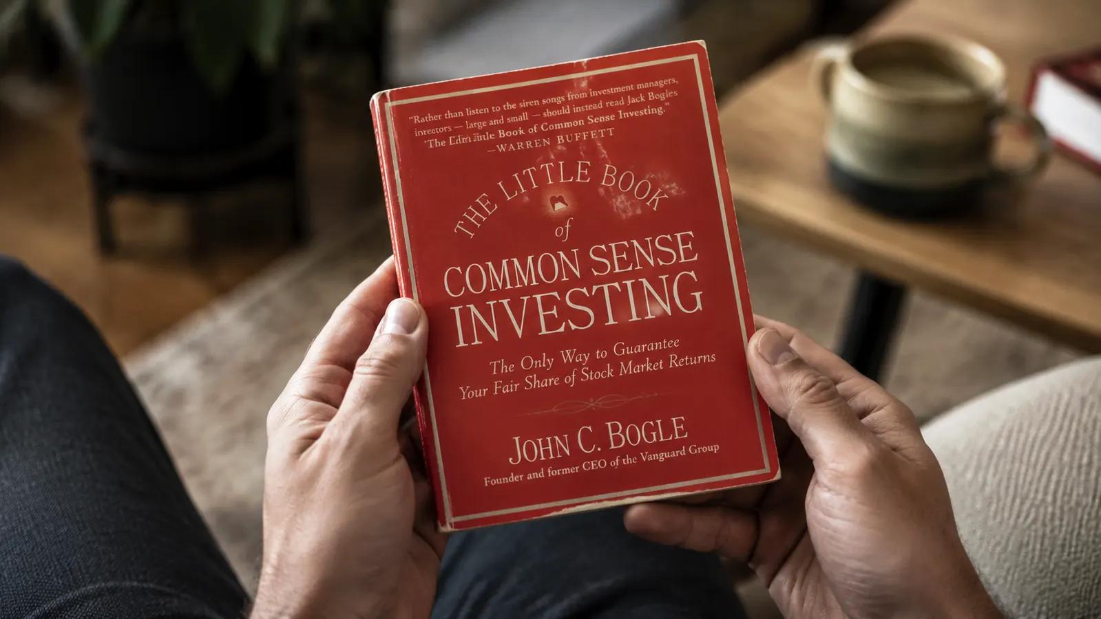 Close-up of The Little Book of Common Sense Investing book cover being held in two hands