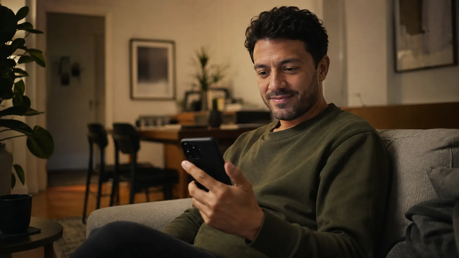 Person looking at a phone showing a retirement account balance with a calm, satisfied expression